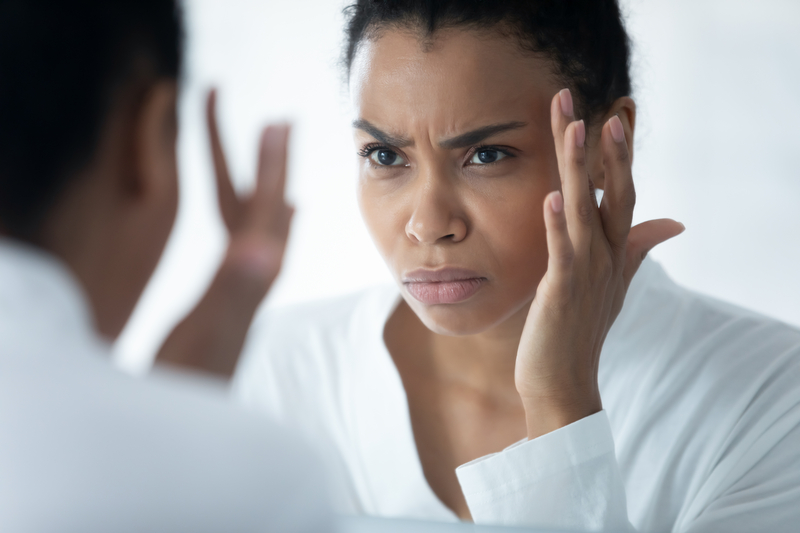 woman checking wrinkles in mirror